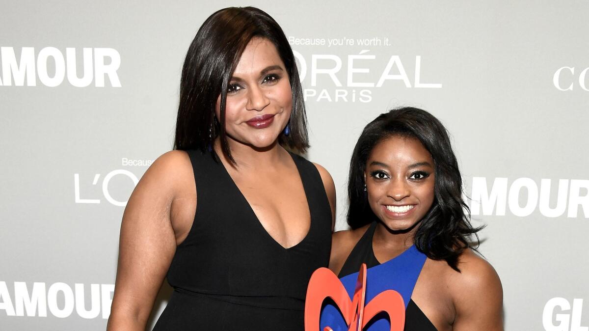 Mindy Kaling, left, and honoree Simone Biles pose with an award at the Glamour Women of the Year event at NeueHouse Hollywood.