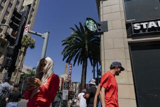 Los Angeles, CA - July 13: Pedestrians walk by the Starbucks on Hollywood Blvd. and Vine St., on Wednesday, July 13, 2022 in Los Angeles, CA. (Wesley Lapointe / Los Angeles Times)