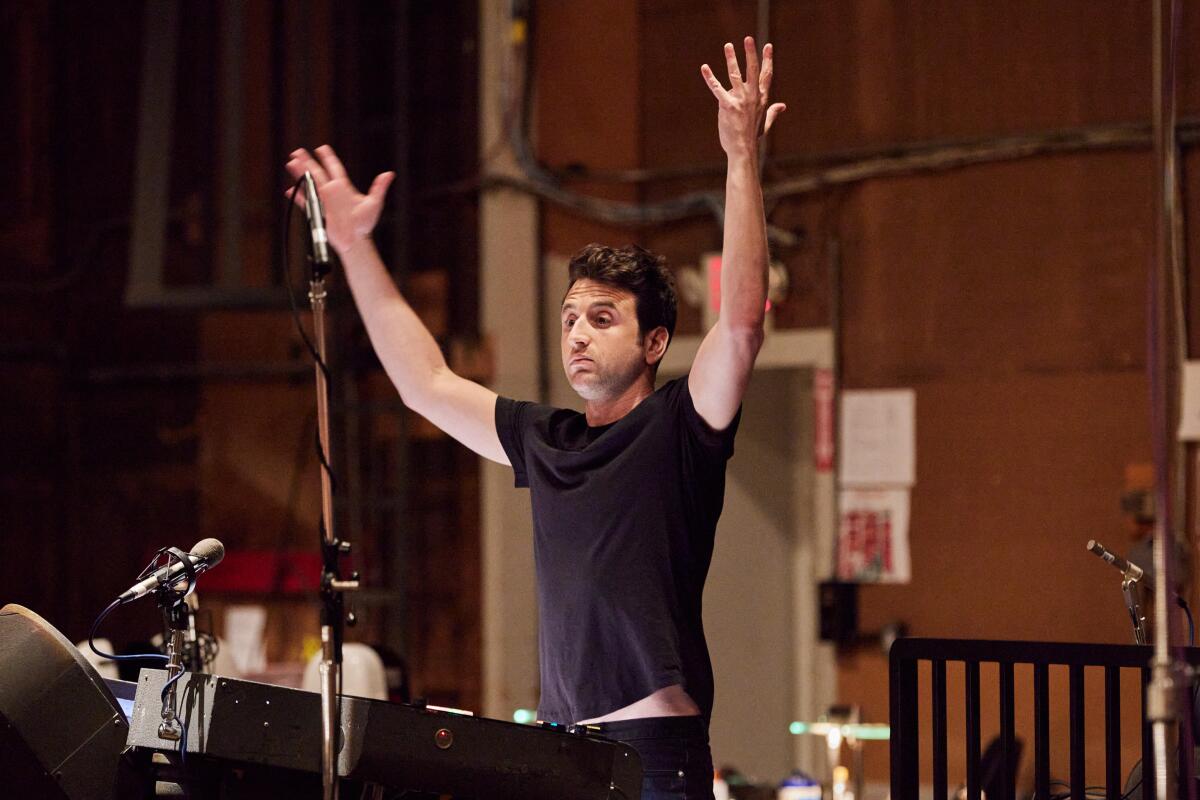 Composer Justin Hurwitz conducts his musicians while working on the "Babylon" scopre.