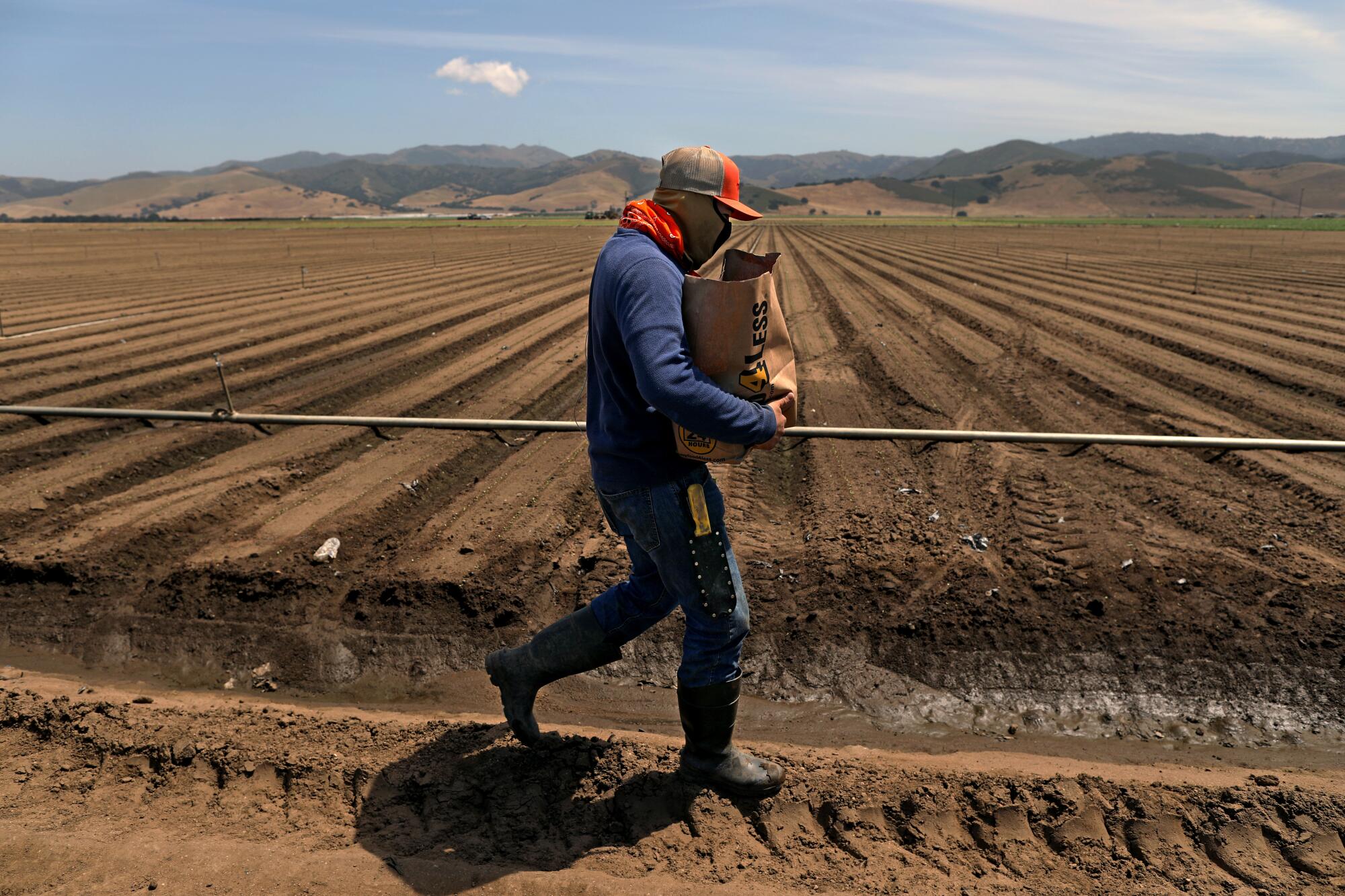 A farmworker with a donation bag containing masks, gloves, food and a hygiene kit