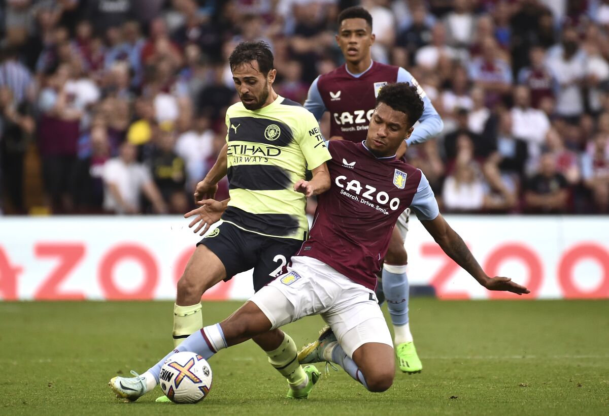 Boubacar Kamara, derecha, del Aston Villa, disputa el balón con Bernardo Silva, del Manchester City, en partido de la Liga Premier en Villa Park, en Birmingham, Inglaterra, el sábado 3 de septiembre de 2022. (AP Foto/Rui Vieira)