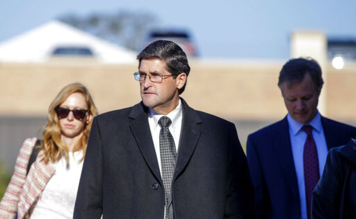 Former St. Tammany Parish Sheriff Jack Strain, center, walks into the parish courthouse before the start of closing arguments in his trial on multiple counts of sex crimes in Covington, La., Monday, Nov. 8, 2021. A jury convicted Strain on all charges Monday night after deliberating for nearly 6 hours. (David Grunfeld/The Advocate via AP)