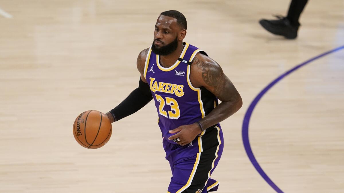 Los Angeles Lakers forward LeBron James dribbles during the first half of an NBA basketball game.