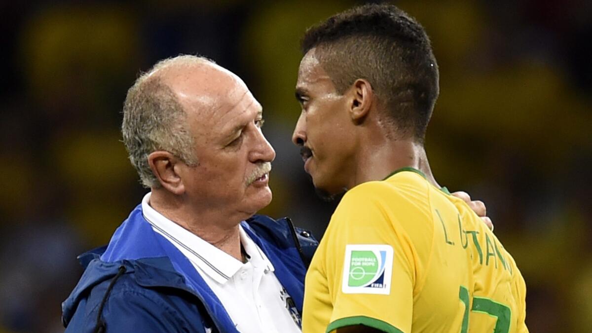 Brazil Coach Luiz Felipe Scolari, left, consoles midfielder Luiz Gustavo after the team's 7-1 loss to Germany in the World Cup semifinals Tuesday.