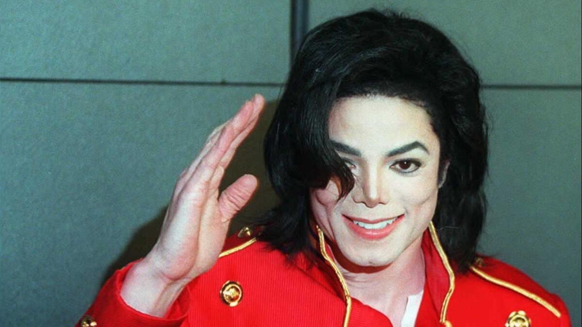 In a photo from March 19, 1996, Michael Jackson waves to photographers during a press conference in Paris. Three Michael Jackson fan groups are suing his alleged victims in France for "sullying his memory" by being in the "Leaving Neverland" documentary, the fans' lawyer said.