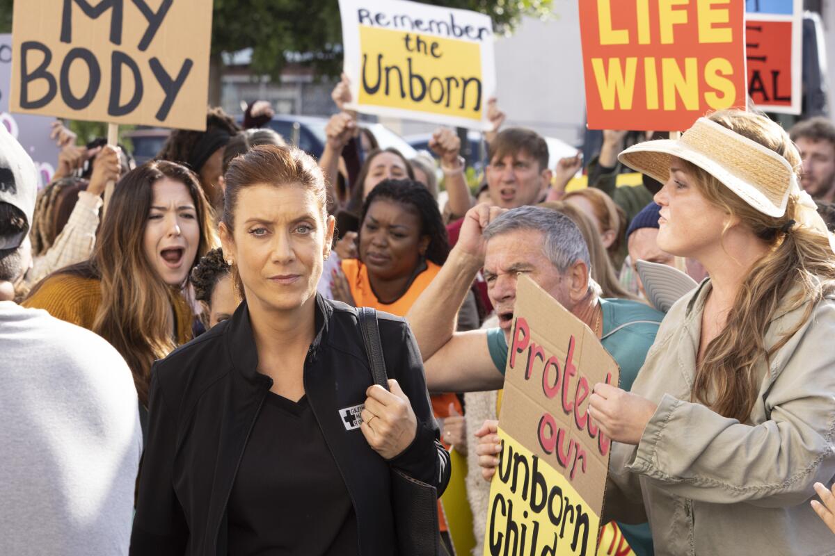  A scene from 'Grey's Anatomy" where protesters hold signs against abortion