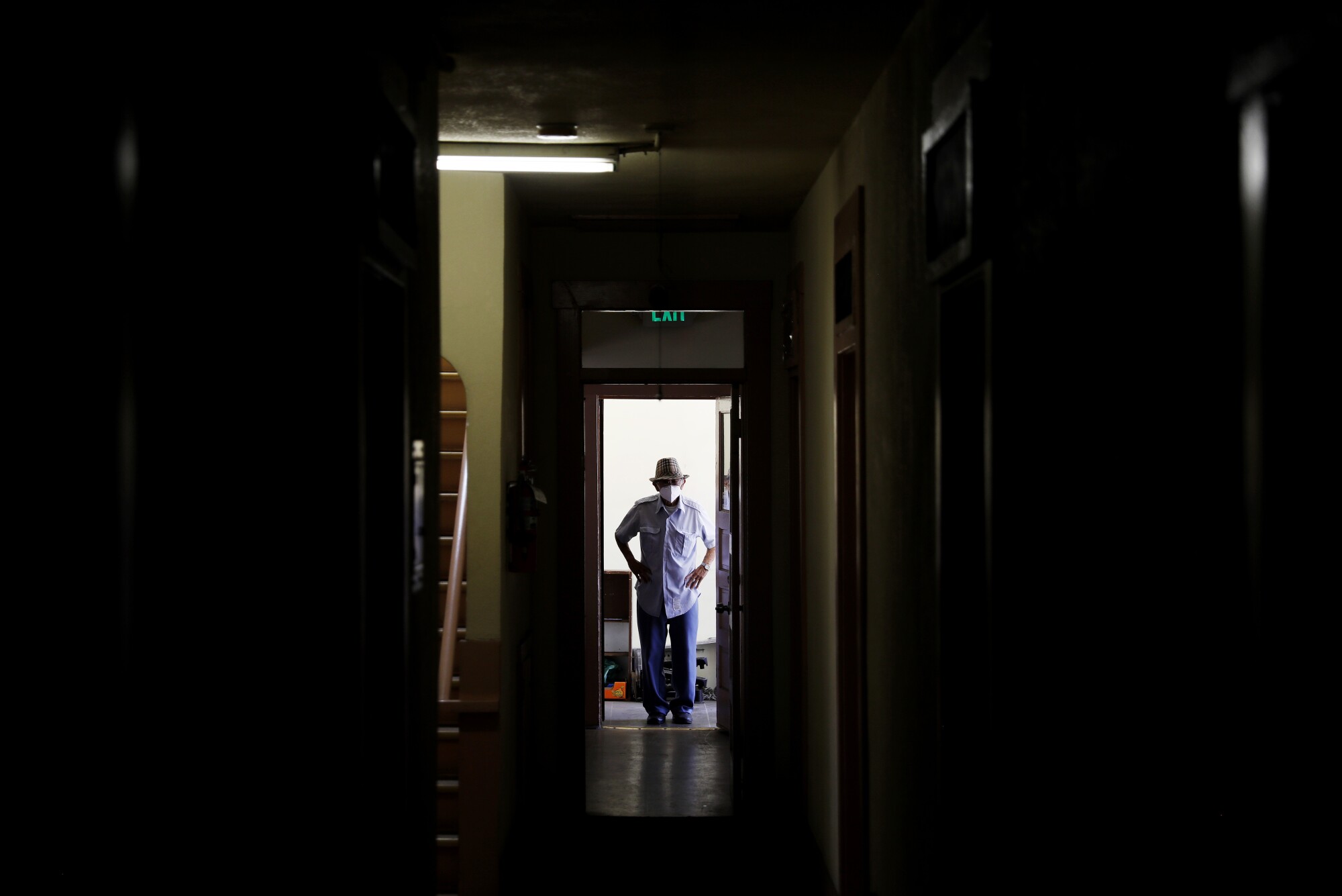 James Niimi stands in a doorway in a dark building 