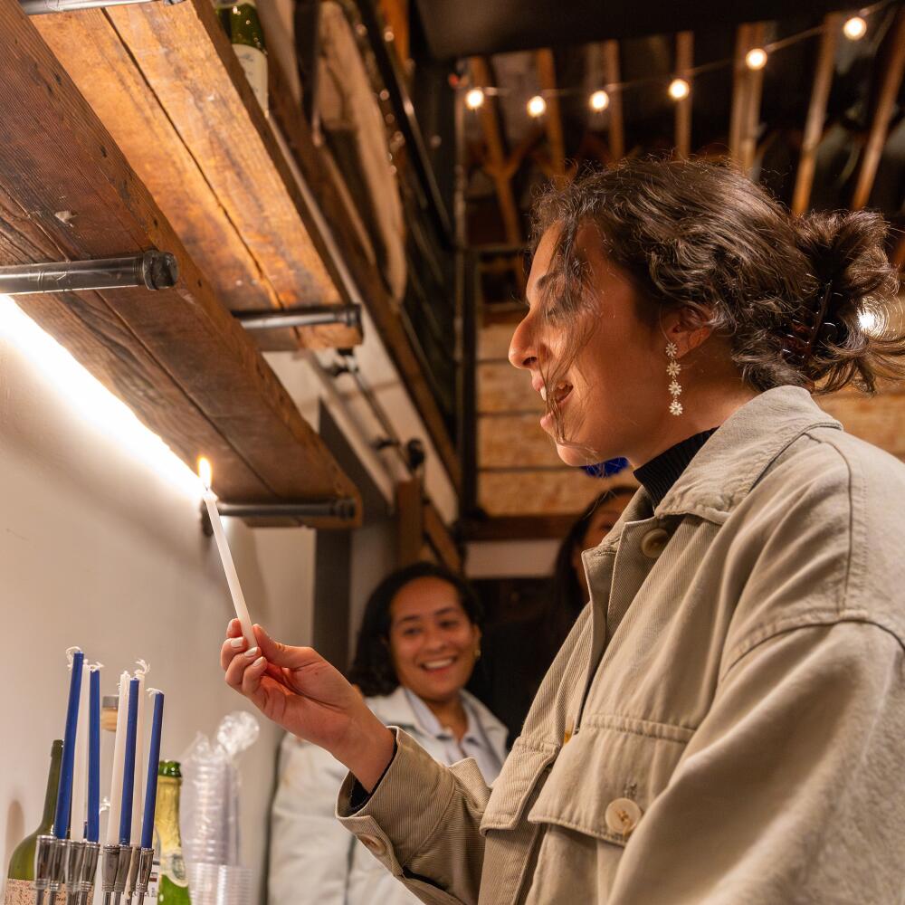 A woman lights a menorah