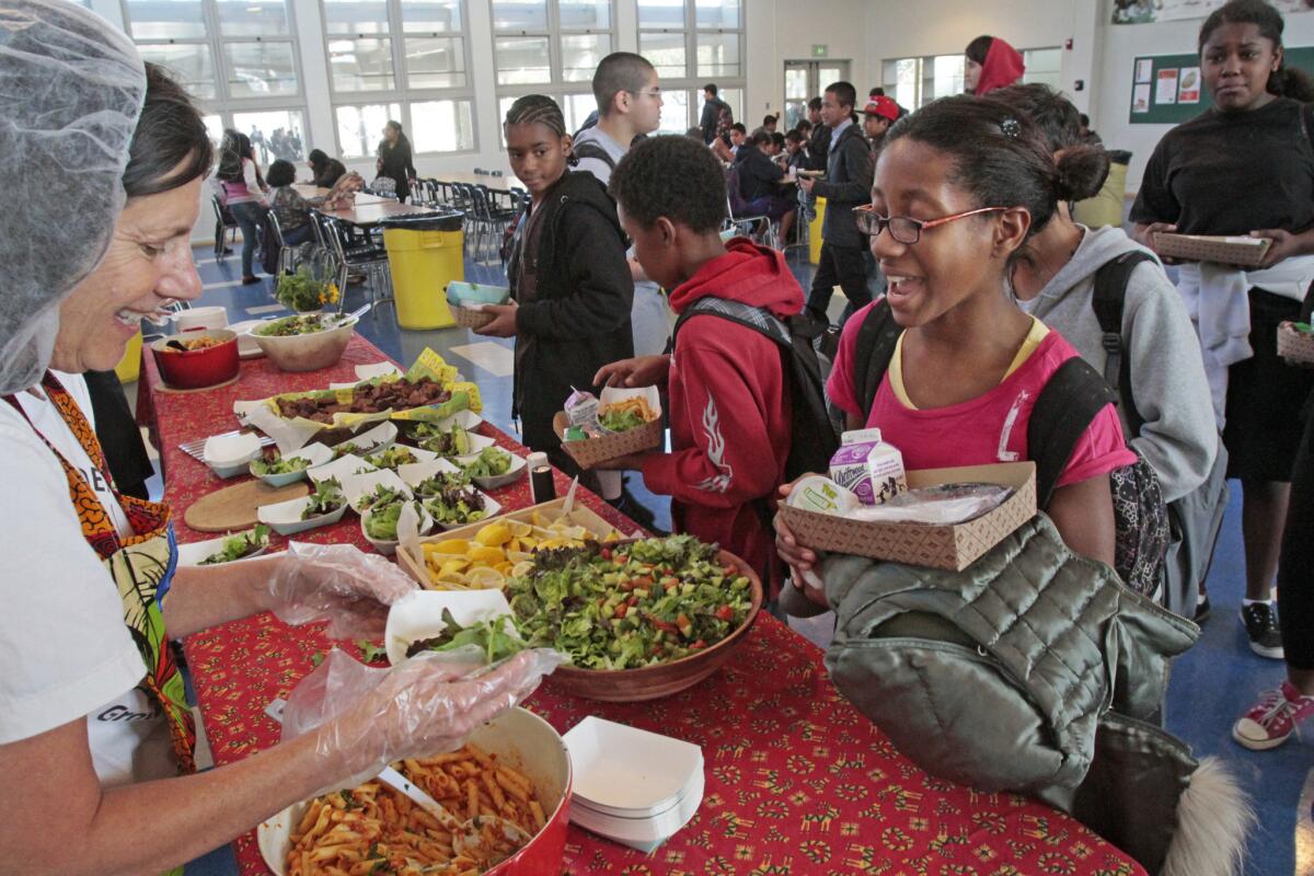 Volunteer Renee Meshul, left, serves Randee Mervin from the garden table at lunch.