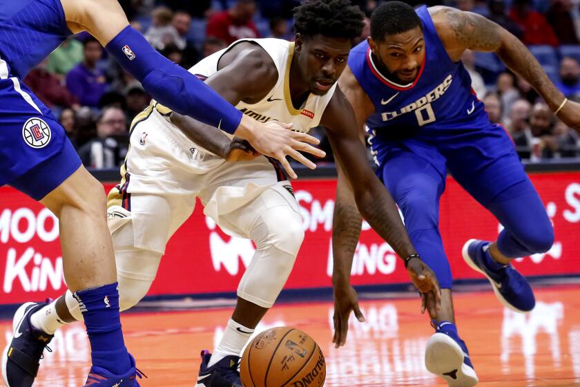 Los Angeles Clippers guard Sindarius Thornwell (0) slaps the ball away from New Orleans Pelicans guard Jrue Holiday, middle, during the first half of an NBA basketball game in New Orleans, Saturday, Nov. 11, 2017. (AP Photo/Scott Threlkeld)