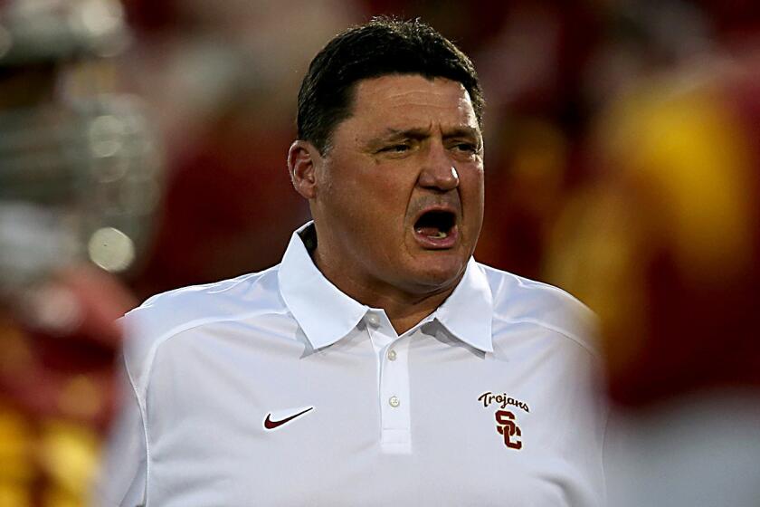 Ed Orgeron watches USC players warm up before a game against UCLA at the Coliseum on Nov. 30, 2013.