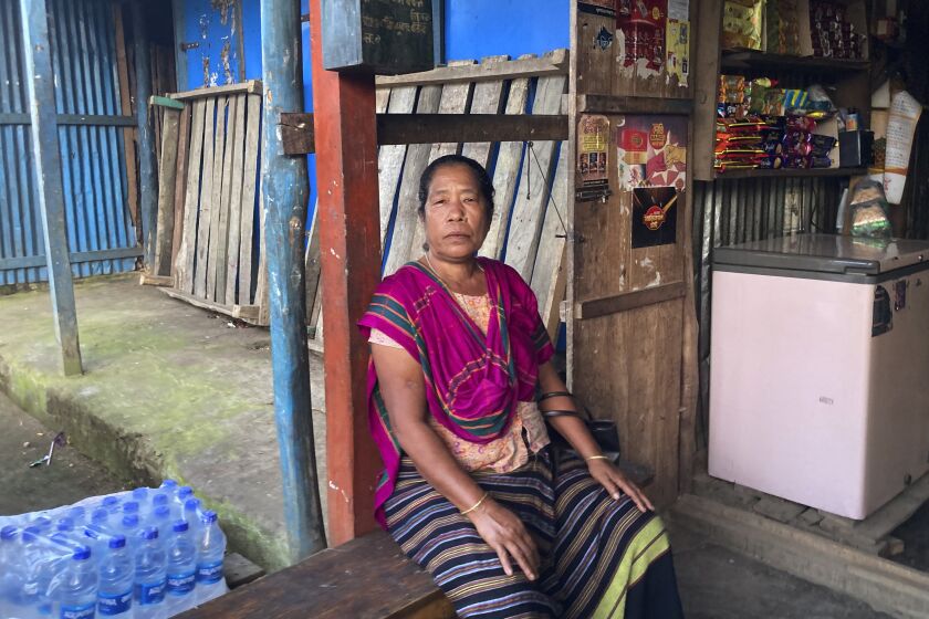 Tribal woman Modhumala Chakma, sits in front of a shop in Rangamati district of Bangladesh, Sunday, Nov. 27, 2022. Bangladesh is marking 25 years since it signed a peace treaty to end an armed insurgency in southeastern Bangladesh. (AP Photo/Al-emrun Garjon)