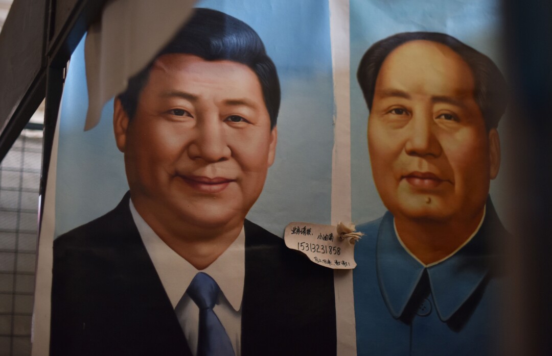 Painted portraits of Chinese President Xi Jinping and Mao Zedong at a market in Beijing.