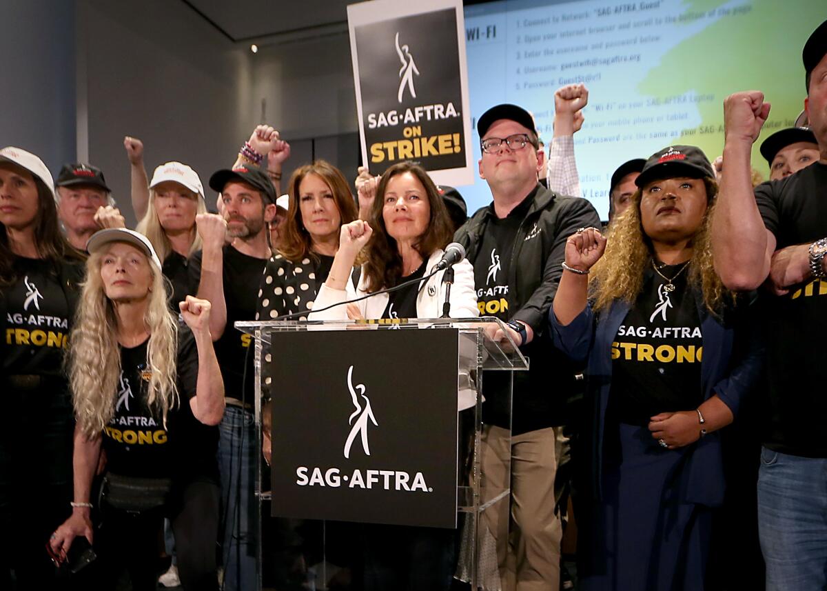 Members of the SAG-AFTRA union raise their fists 