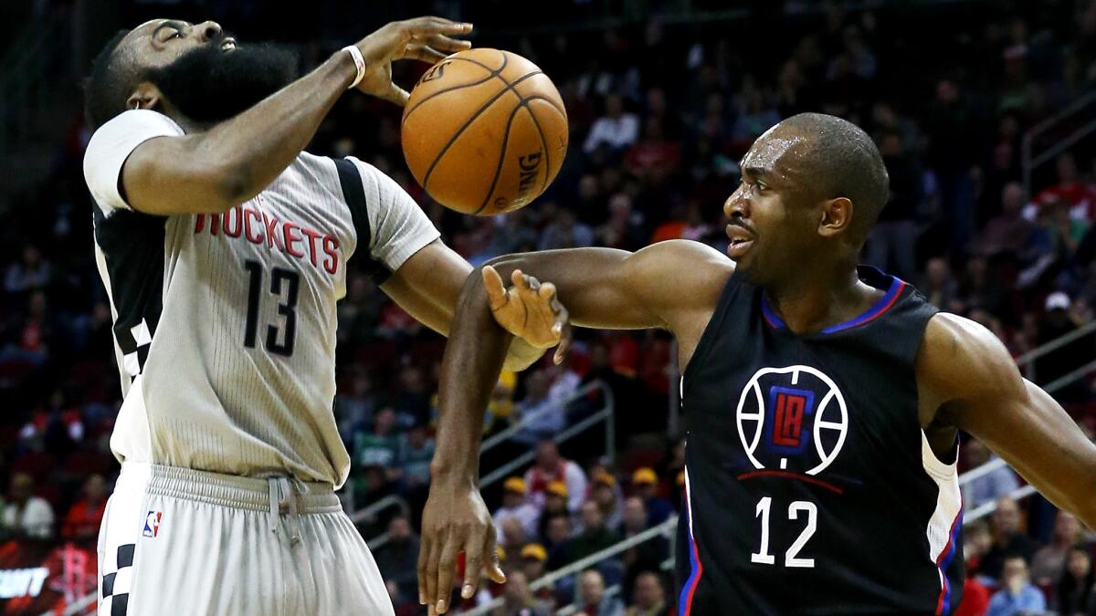 Rockets guard James Harden is fouled by Clippers forward Luc Mbah a Moute during their game Saturday.