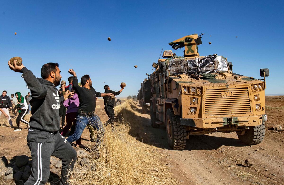 Kurdish demonstrators hurl rocks at a Turkish military vehicle on Nov. 8
