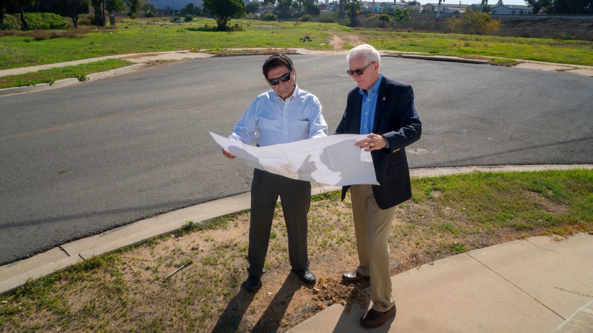 Jean Diaz, executive director of the San Diego Community Land Trust (left), and Tom Scott, board member and chief financial officer, stand at the Nestor site where the Land Trust wants to build its first 16 affordable houses.