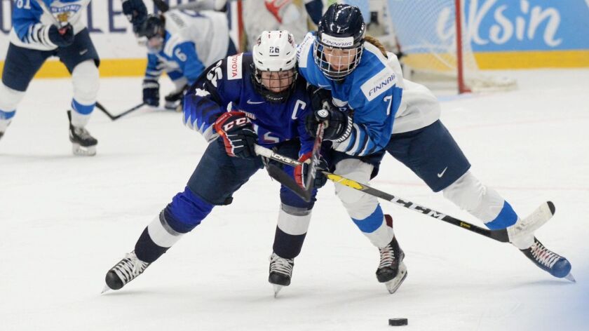 U.S. player Kendall Coyne Schofield, left, and Finland's Nelli Laitinen vie for the puck on April 14 in Finland.