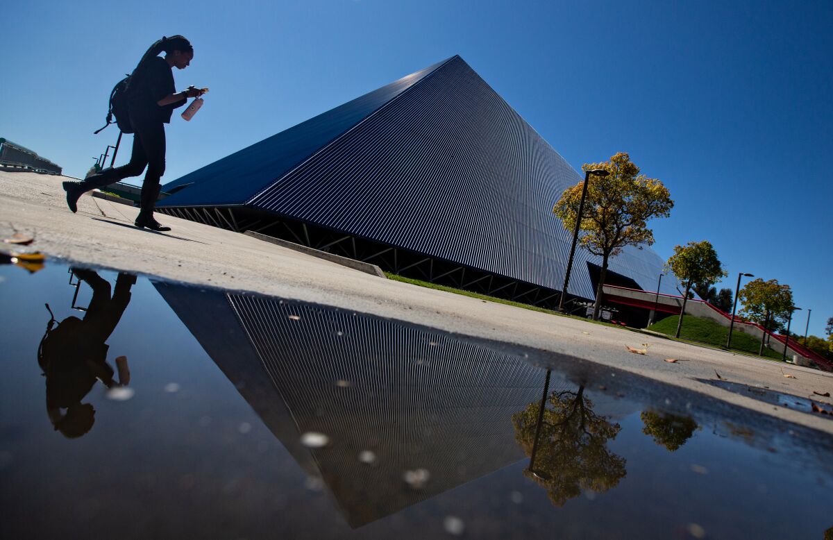 A student walks past the Walter Pyramid at Cal State Long Beach.