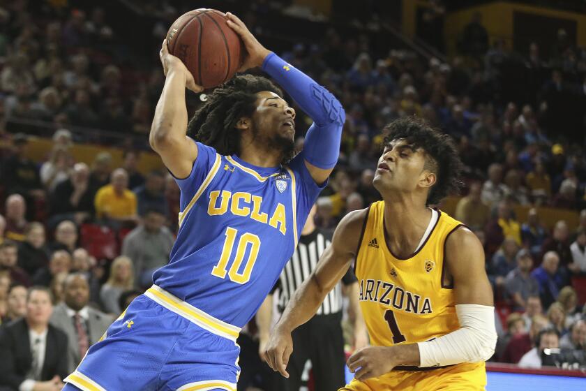 UCLA's Tyger Campbell (10) looks to pass as Arizona State's Remy Martin (1) defends during the first half of an NCAA college basketball game Thursday, Feb. 6, 2020, in Tempe, Ariz. (AP Photo/Darryl Webb)