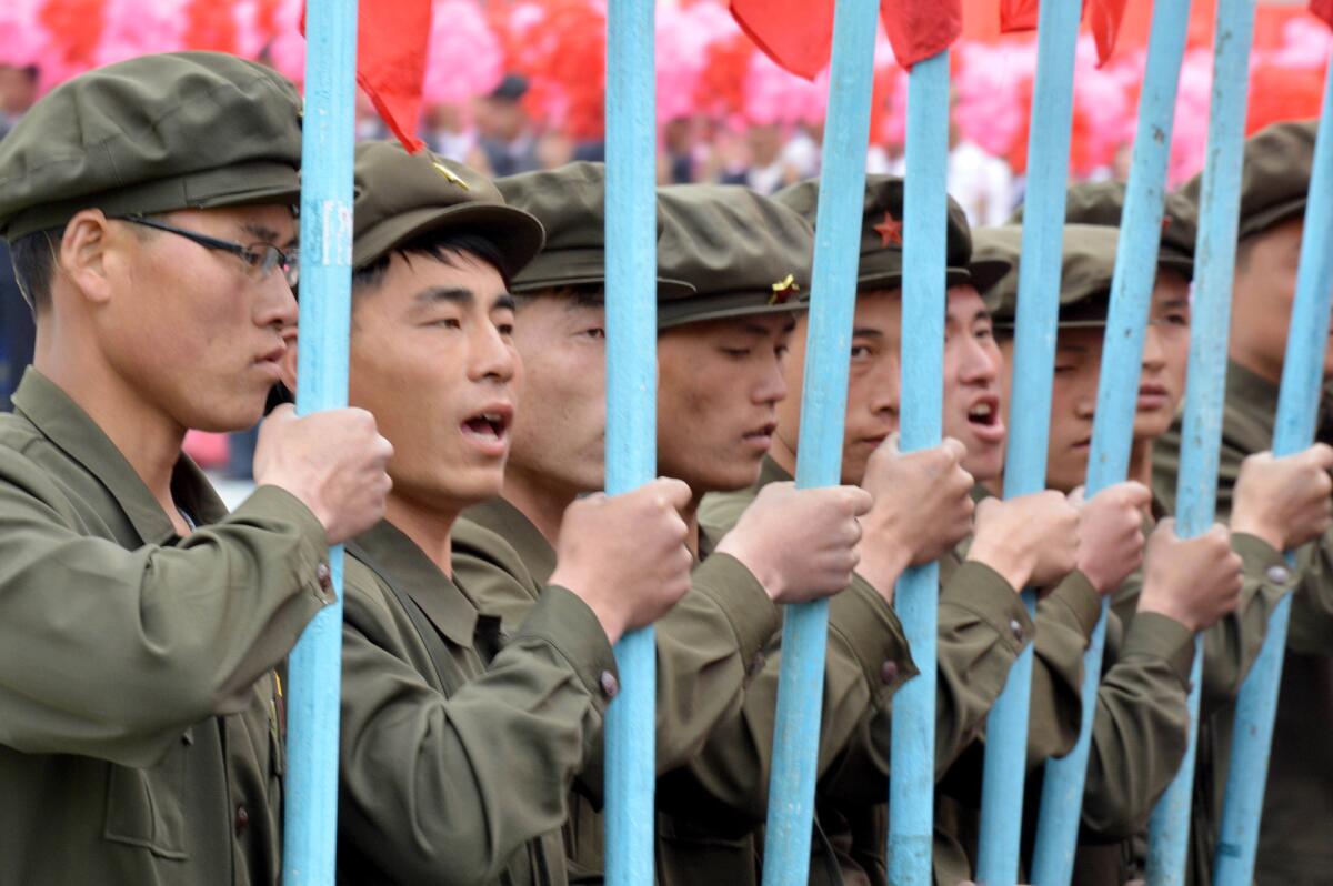 Participants carry the ruling Workers' Party flag as they march during the parade.