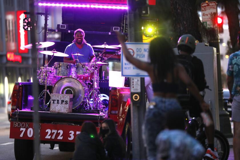 LOS ANGELES-CA-MAY 1, 2020: Anthony Sheriff, 32, plays the drums in a truck bed in downtown Los Angeles, California on Friday, May 1, 2020. (Christina House / Los Angeles Times)