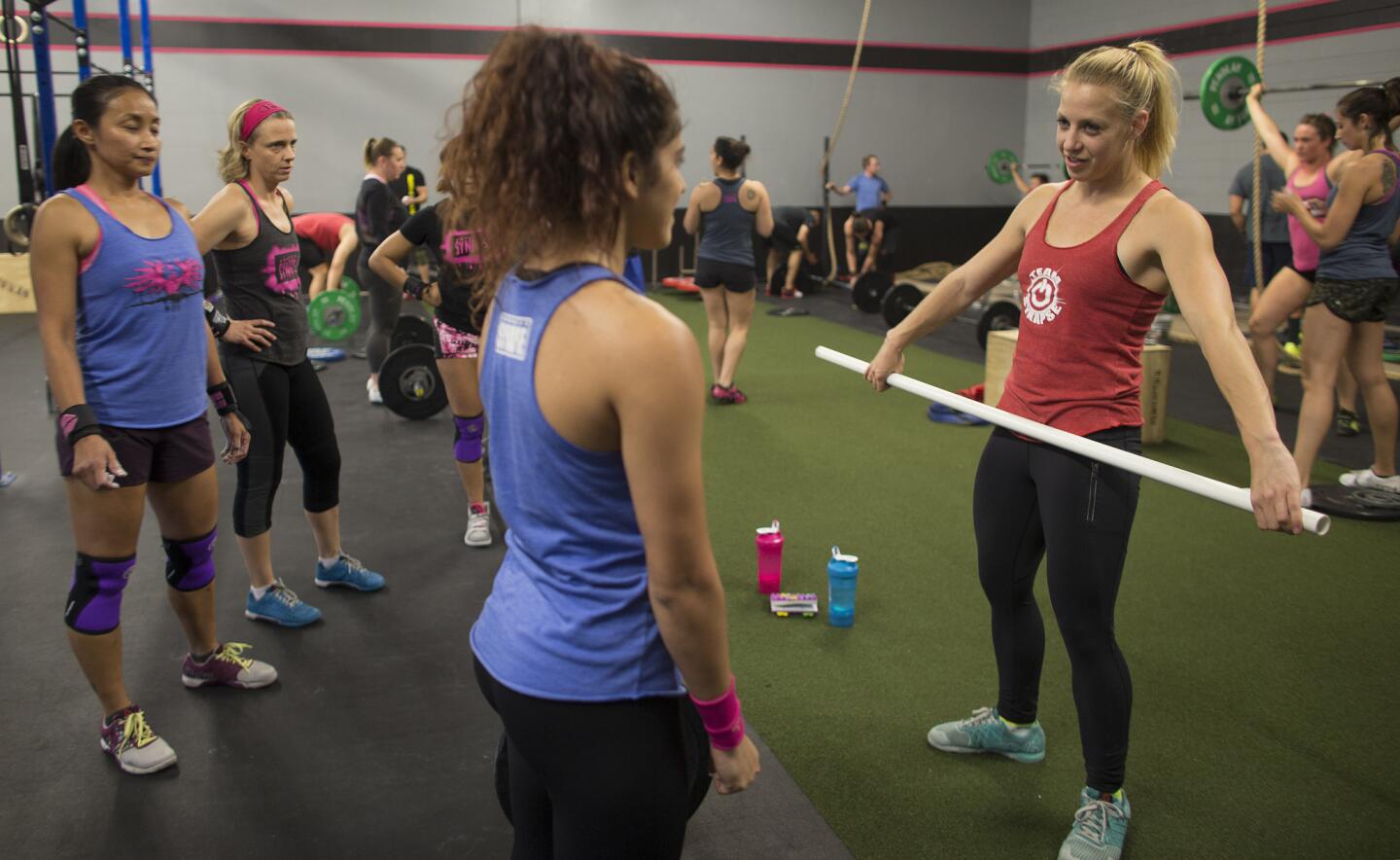 CrossFit gym owner Allison Truscheit, right, teaches technique during her barbell strength training class in North Hollywood. More women are discovering the benefits of strength training.