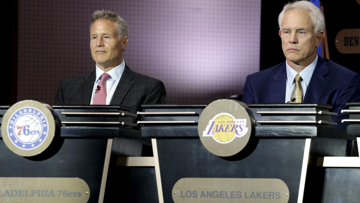 Lakers General Manager Mitch Kupchak, right, listens along with 76ers Coach Brett Brown as the results of the NBA draft lottery are announced Tuesday.