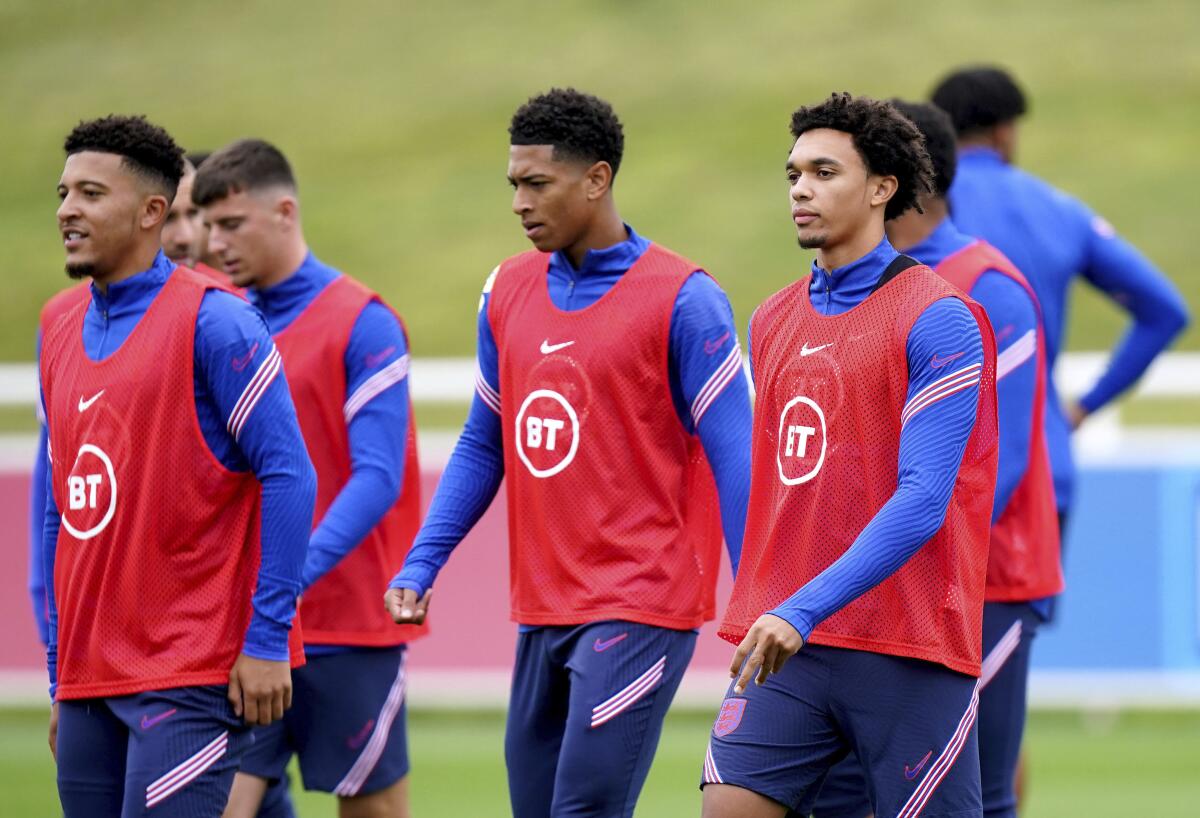 England's players Trent Alexander-Arnold, right, Jude Bellingham, center, and Jadon Sancho attend a training session at St George's Park, Burton upon Trent, Wednesday Sept. 1, 2021. England plays Hungary in a group I World Cup soccer qualifier on Thursday in Budapest. (Mike Egerton/PA via AP)