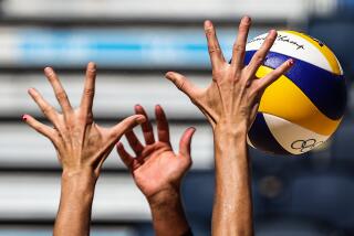 Tokyo, Japan,Thursday, August 5, 2021 - Alix Klineman stretches her fingers to the limit in an attempt to block the spike of Switzerland's Joana Heidrich at the Tokyo 2020 Olympics Beach Volleyball at Shiokaze Park. (Robert Gauthier/Los Angeles Times)