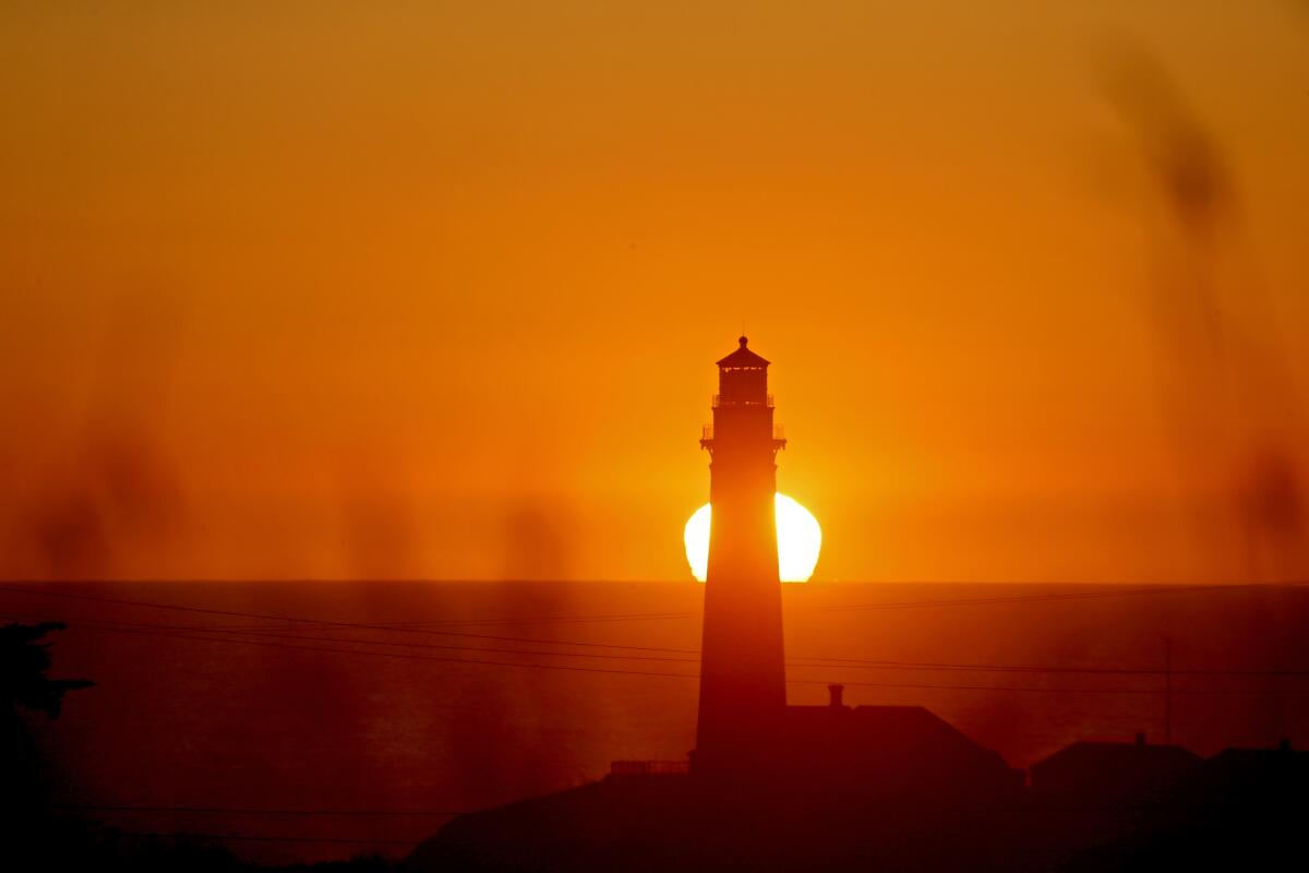 Sunset behind a lighthouse.