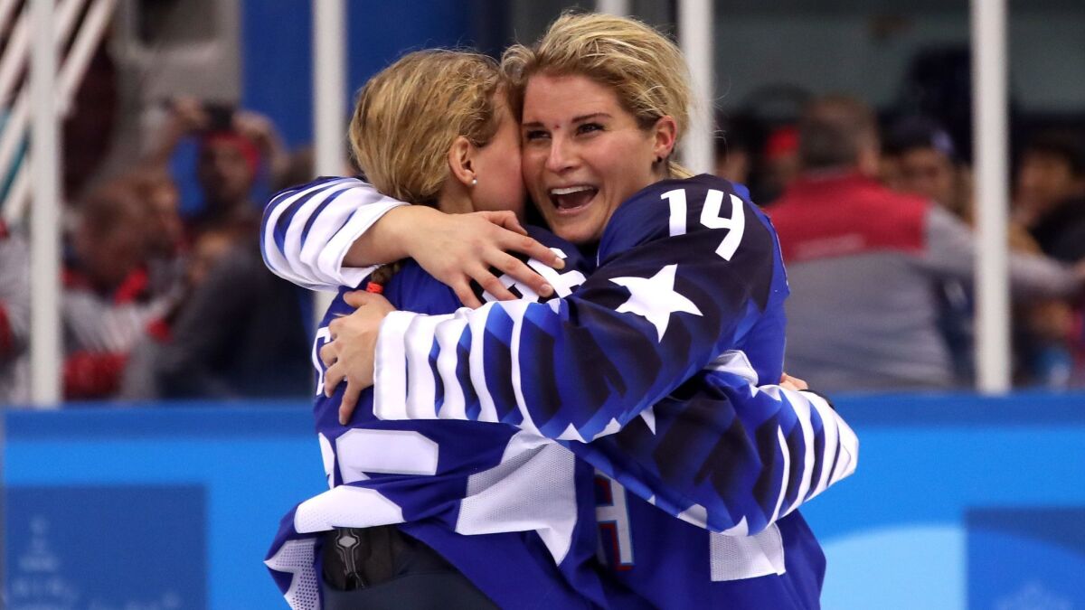 Brianna Decker (14) embraces a teammate after the U.S. defeated Canada in the gold-medal game of the 2018 Winter Olympics.