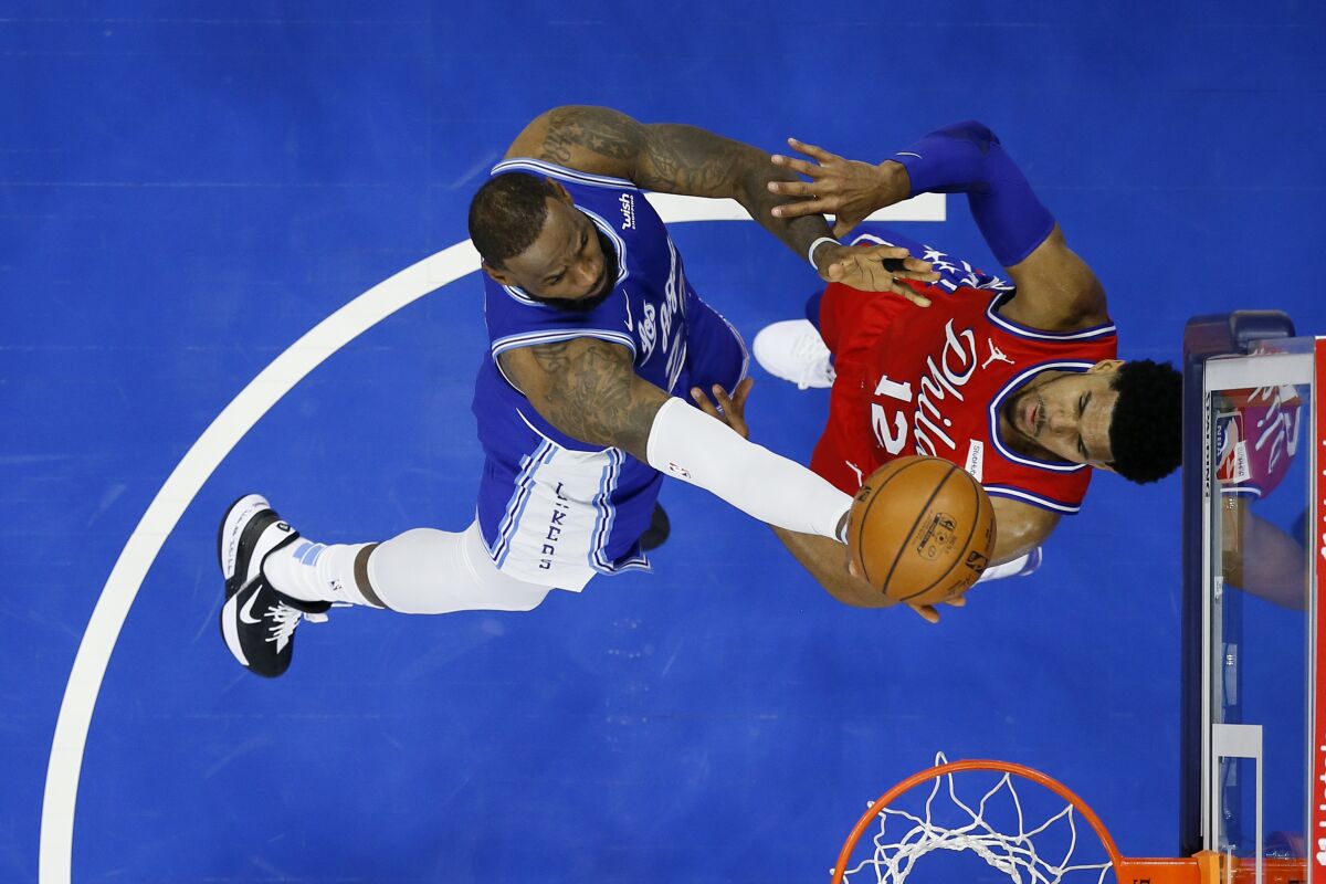 LeBron James, left, goes up for a shot over Philadelphia 76ers forward Tobias Harris during a Lakers loss on Jan. 27.