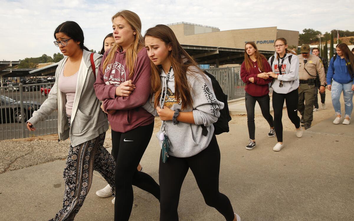 Police officers escort students away from Saugus High School after a gunman opened fire on the Santa Clarita campus early Thursday.