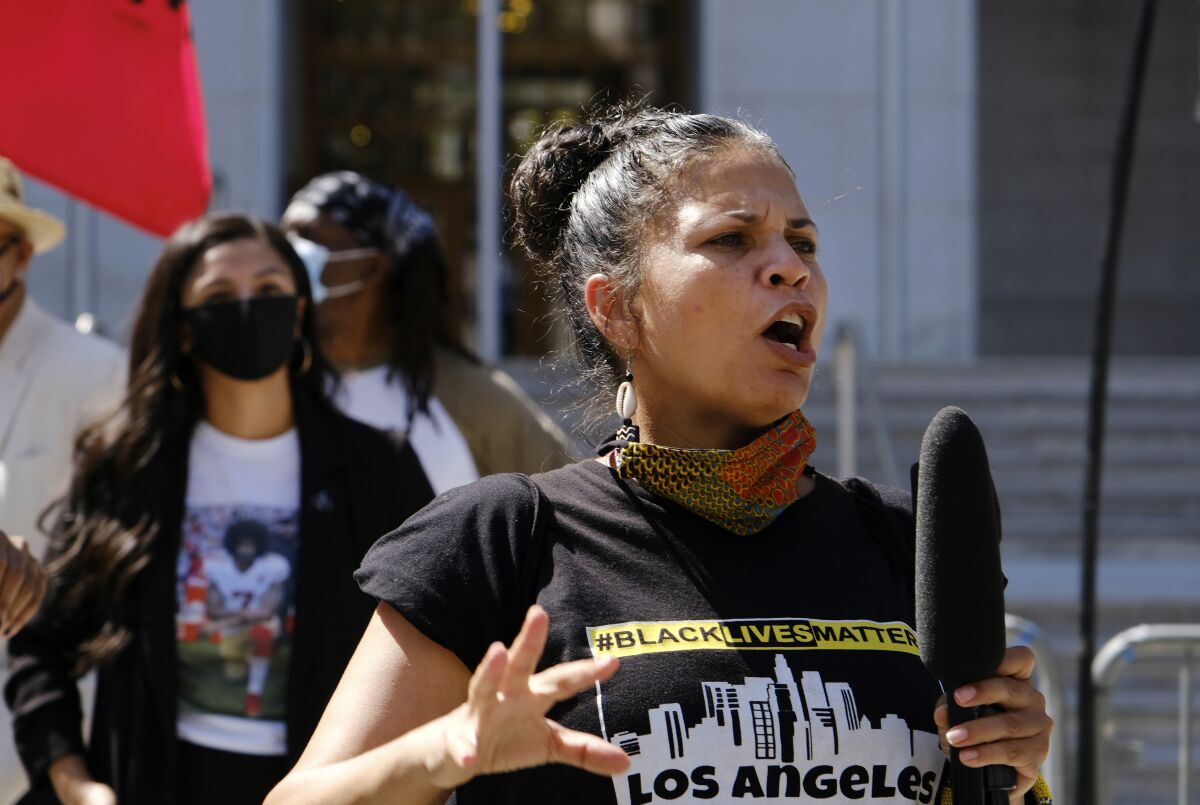FILE - In this Aug. 5, 2020 file photo, Melina Abdullah speaks during a Black Lives Matter protest at the Hall of Justice in downtown Los Angeles. Authorities say three teenagers driven by racial hatred were behind hoax calls that brought major police responses to the home of Abdullah, a leading Black Lives Matter activist in Los Angeles. (AP Photo/Richard Vogel, File)