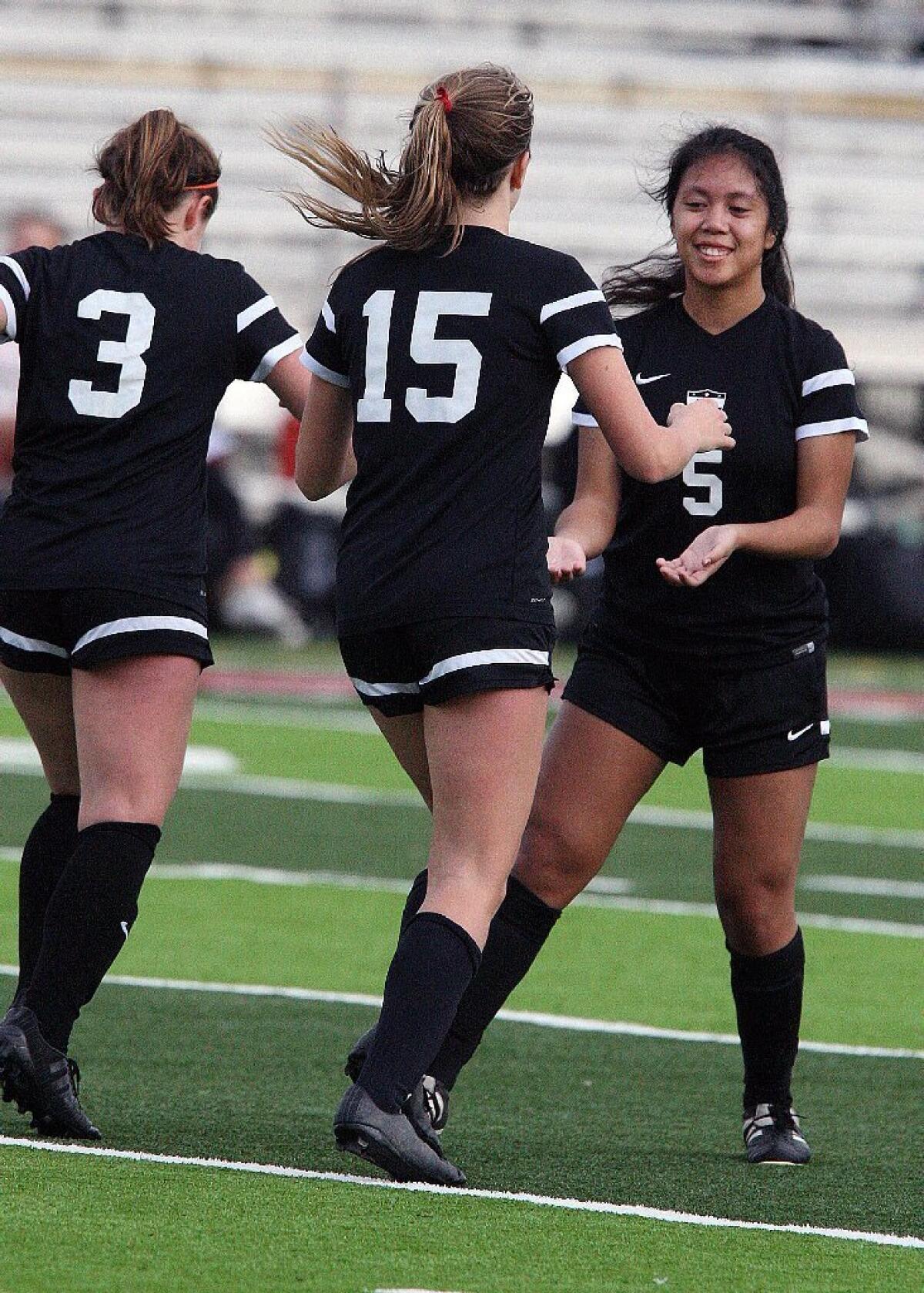 Flintridge Sacred Heart's Jillian Willis and Grace Lawlor congratulate teammate Amethyst Trang after scoring the first goal of the match off a direct kick in a city rivalry girls' soccer game at La Cañada High on Monday.