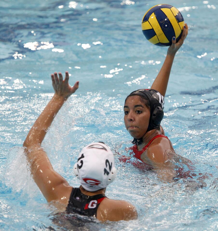 Burroughs High School's #19 Yesenia Esparza takes a shot on goal as Glendale High's #12 Naira Sarkian puts her hand up during Pacific League Tournament game vs. Glendale High at Burbank High School in Burbank on Tuesday, February 5, 2013. Burroughs won the game 5-2.