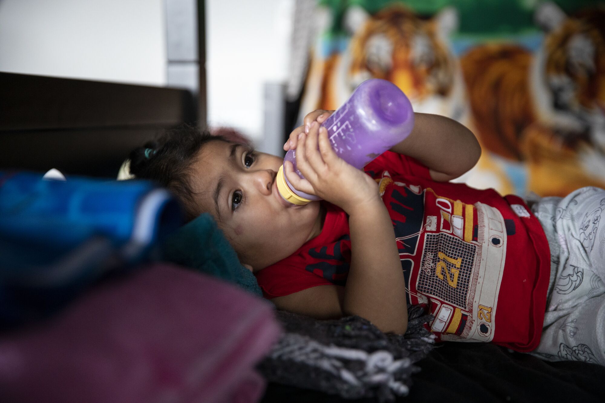 Marlexy Martinez, 1, drinks from a bottle after waking up at Espacio Migrante on Thursday in Tijuana , Baja California.
