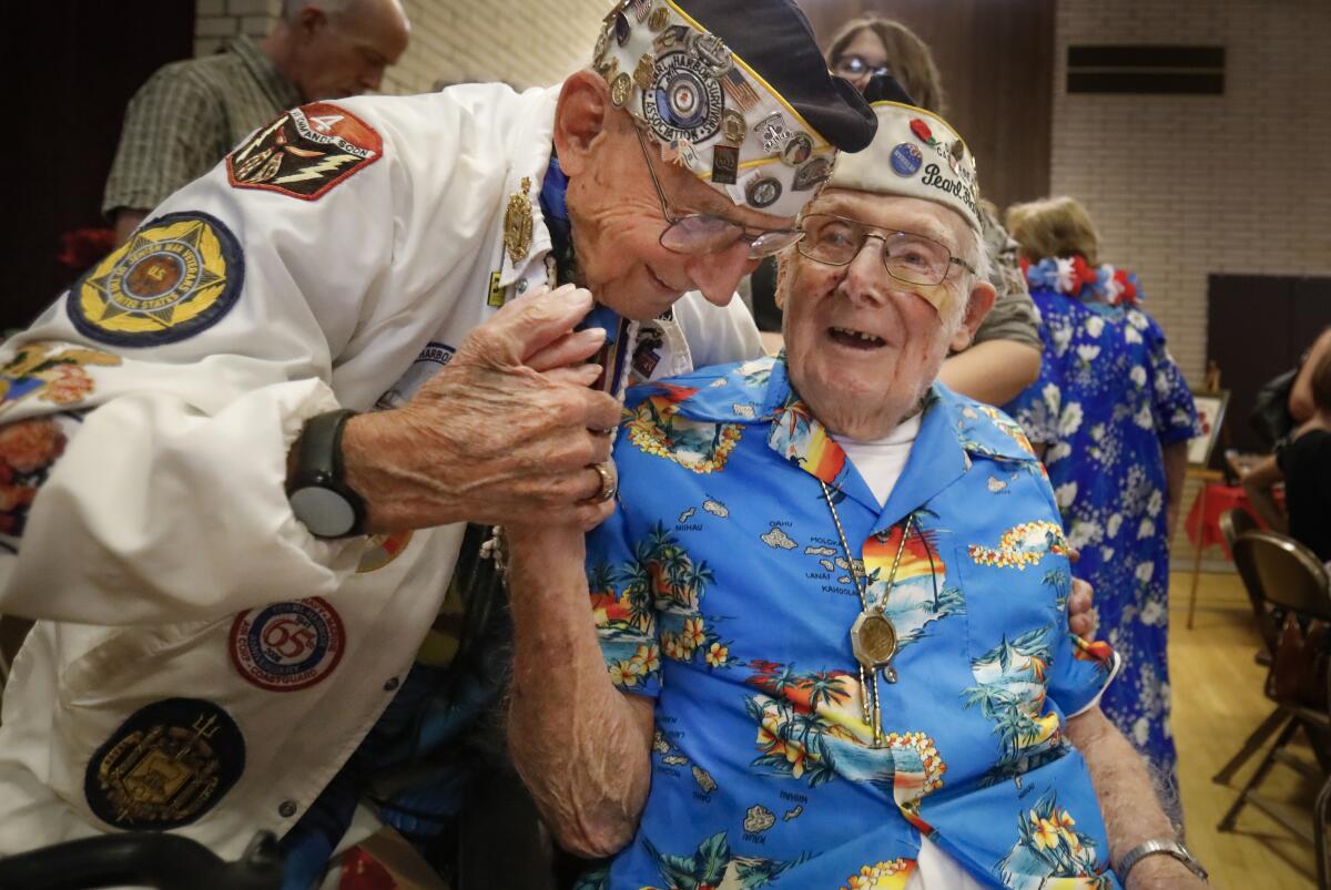 Stuart Hedley, 97, left, president of the San Diego Chapter of the Pearl Harbor Survivors Assn., Carnation Chapter 3, and fellow member Clayton Schenkelberg, 101, greet one another on Saturday at the Church of Jesus Christ of Latter-Day Saints in La Mesa, Calif., before the annual chapter birthday luncheon, which included the last official board meeting of the group before the chapter is discontinued.