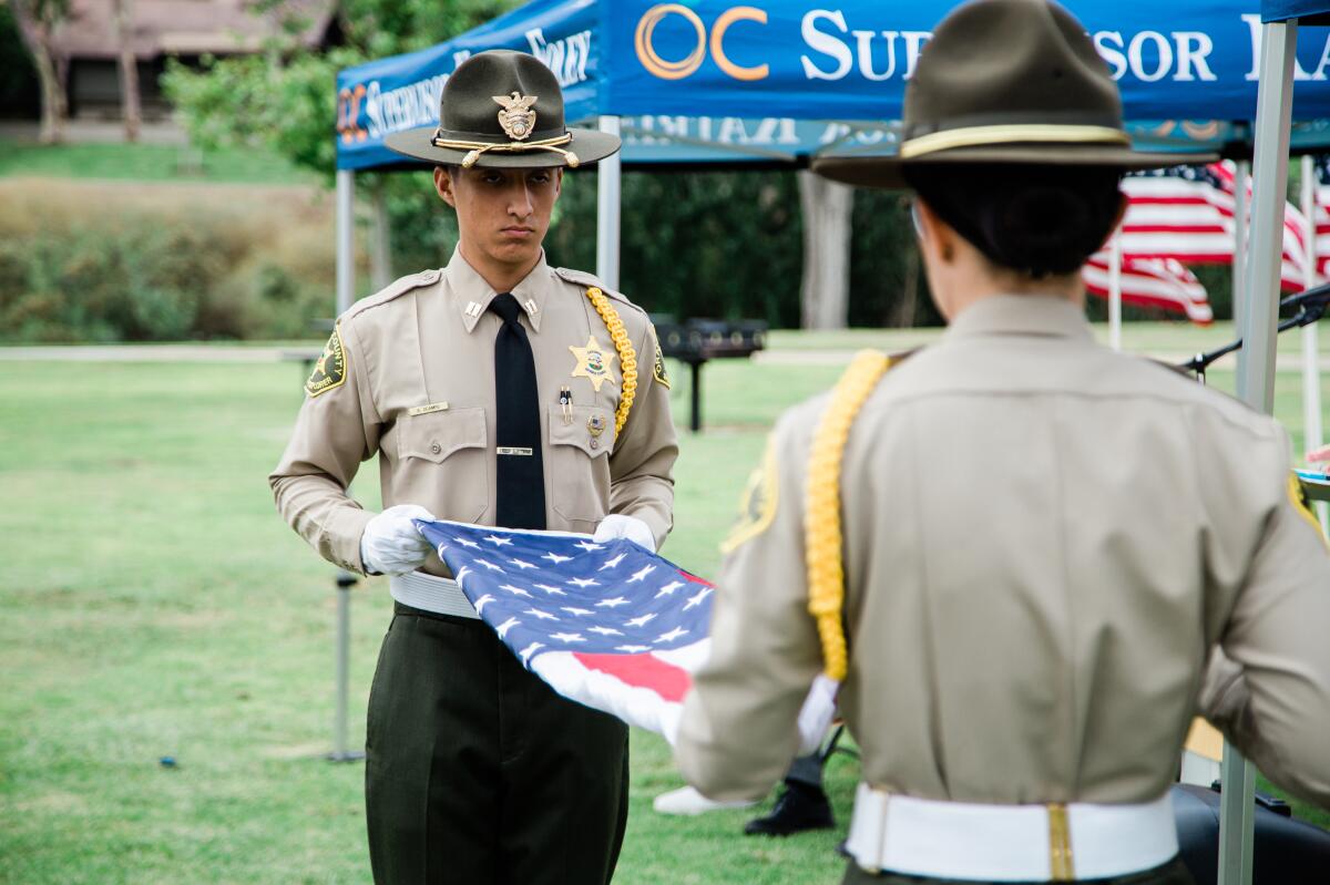 Members of the Orange County Sheriff's Department Explorers fold a U.S. flag.