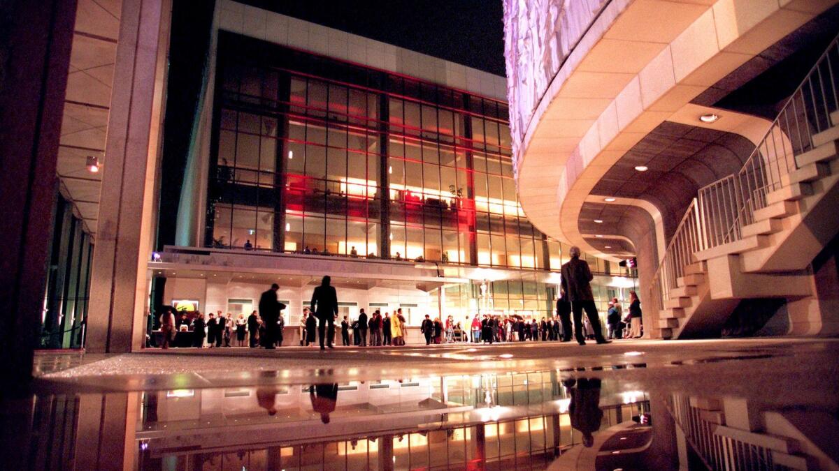 Theatre-goers brave the rain to attend the re-opening of the Ahmanson Theatre for the premiere of "Miss Saigon" in 1995.