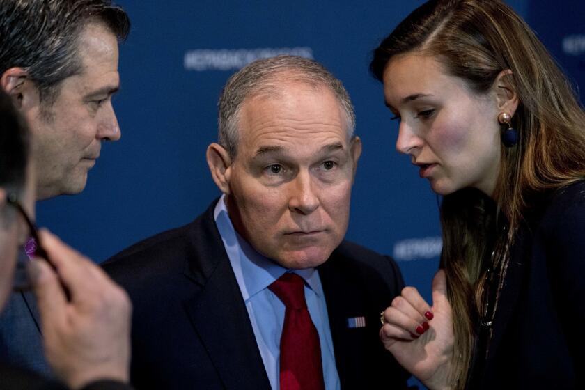 Environmental Protection Agency Administrator Scott Pruitt speaks with an aide during a news conference at the EPA in Washington on April 3, 2018.