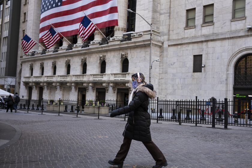 A pedestrian passes the New York Stock Exchange Monday, March 16, 2020. (AP Photo/Craig Ruttle)