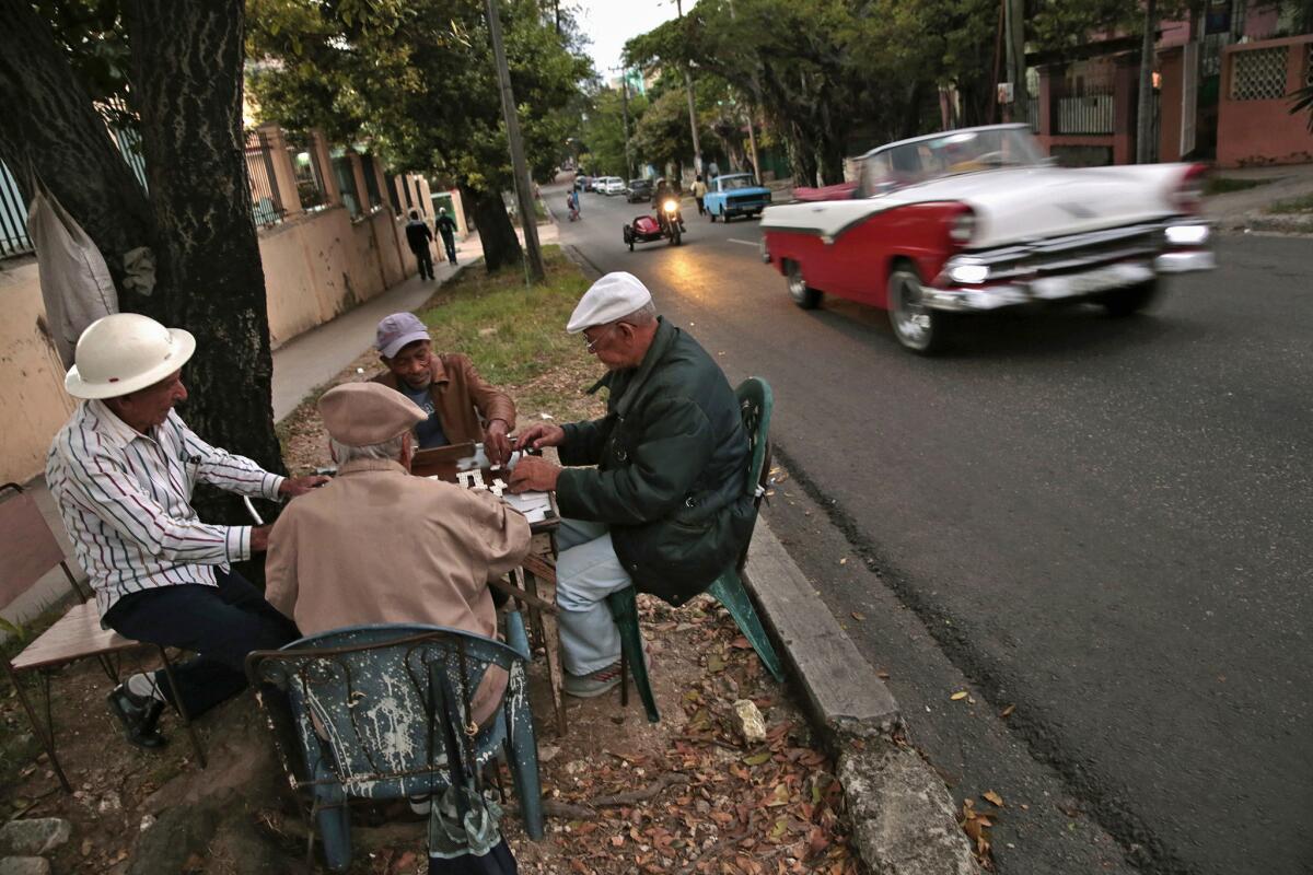 Men share a game of dominoes on the side of the road in Havana, a destination on a Cuba tour offered by the L.A. World Affairs Council.
