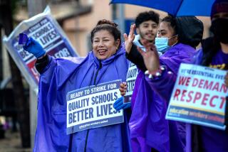 LOS ANGELES, CA - MARCH 22: Yadira Martinez, 53, left, works for LAUSD as special education assistant, on strike joins the picket line at Florence Ave Elementary School on Wednesday, March 22, 2023 in Los Angeles, CA. (Irfan Khan / Los Angeles Times)