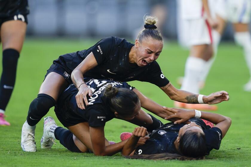 Angel City FC defender Mary Alice Vignola, top, celebrates with forward Alyssa Thompson, center, and defender Madison Hammond, after Hammond's goal during the second half of an NWSL soccer match against the OL Reign, Sunday, Aug. 27, 2023, in Los Angeles. (AP Photo/Ryan Sun)