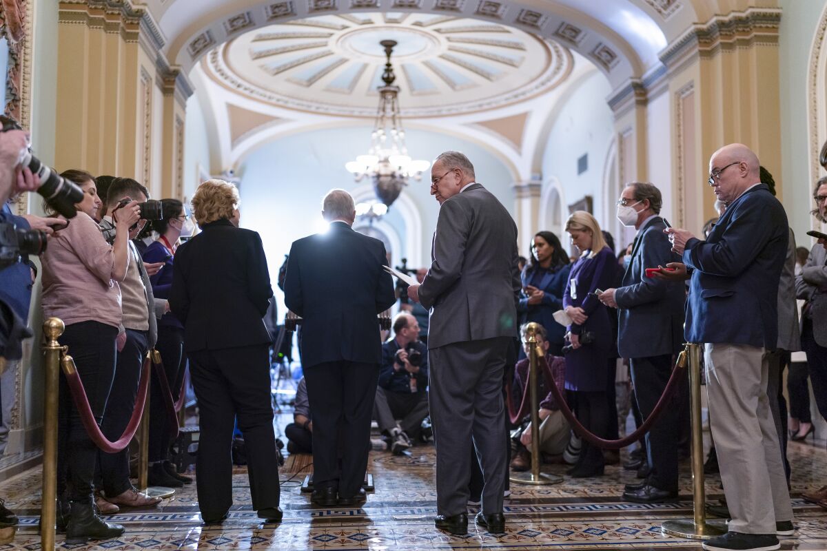 Senate Majority Leader Chuck Schumer, D-N.Y., center, arrives to speak to reporters about the Russian invasion of Ukraine following a Democratic strategy meeting at the Capitol in Washington, Tuesday, March 8, 2022. (AP Photo/J. Scott Applewhite)