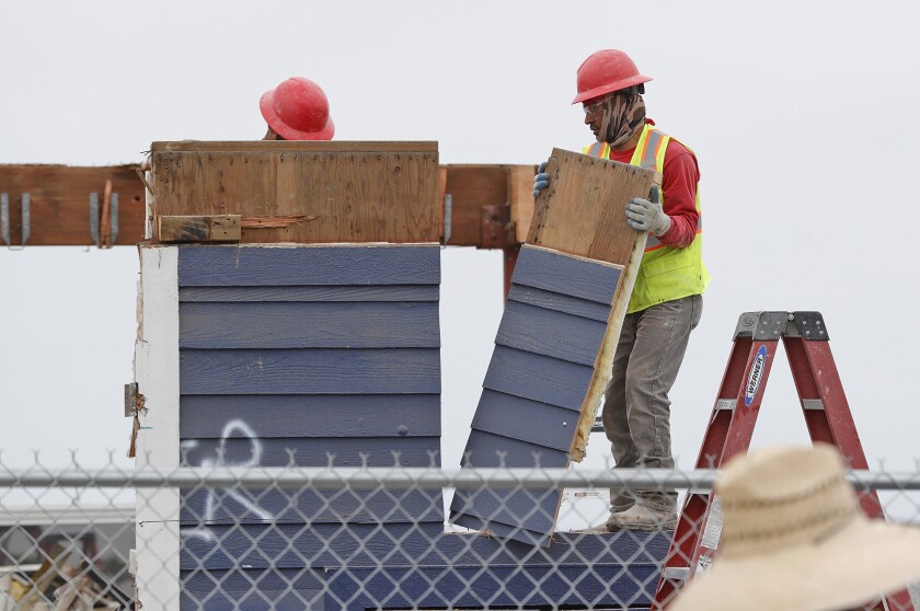 Workers dismantle the last wall panel of the restaurant at the end of Newport Pier on Thursday.