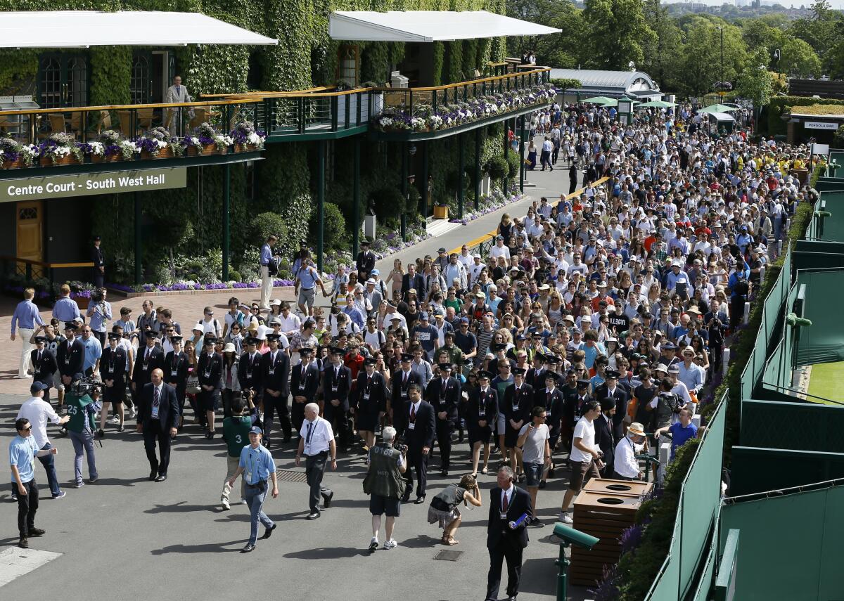 ARCHIVO - En esta foto del lunes 29 de junio de 2015, el público ingresa al complejo de canchas del torneo de Wimbledon 