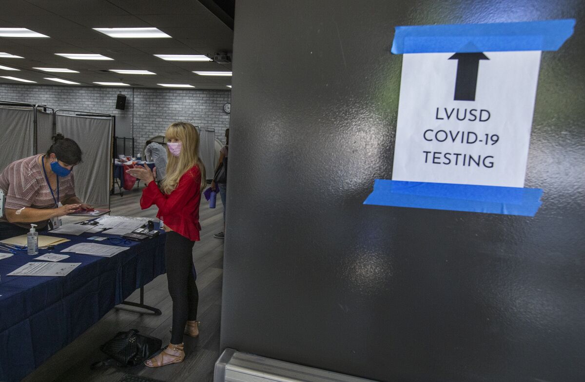 A teacher checks in for a COVID-19 test.